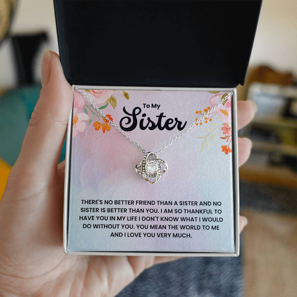 To My Sister love knot necklace with cubic zirconia, symbolizing an unbreakable bond, presented in a floral gift box with heartfelt message.