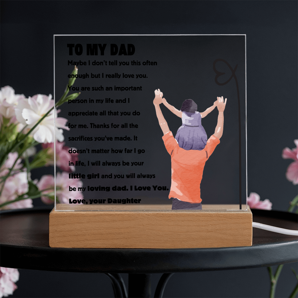 Square acrylic plaque with "To My Dad" message, featuring a daughter on dad's shoulders, set on a wooden stand against floral background.