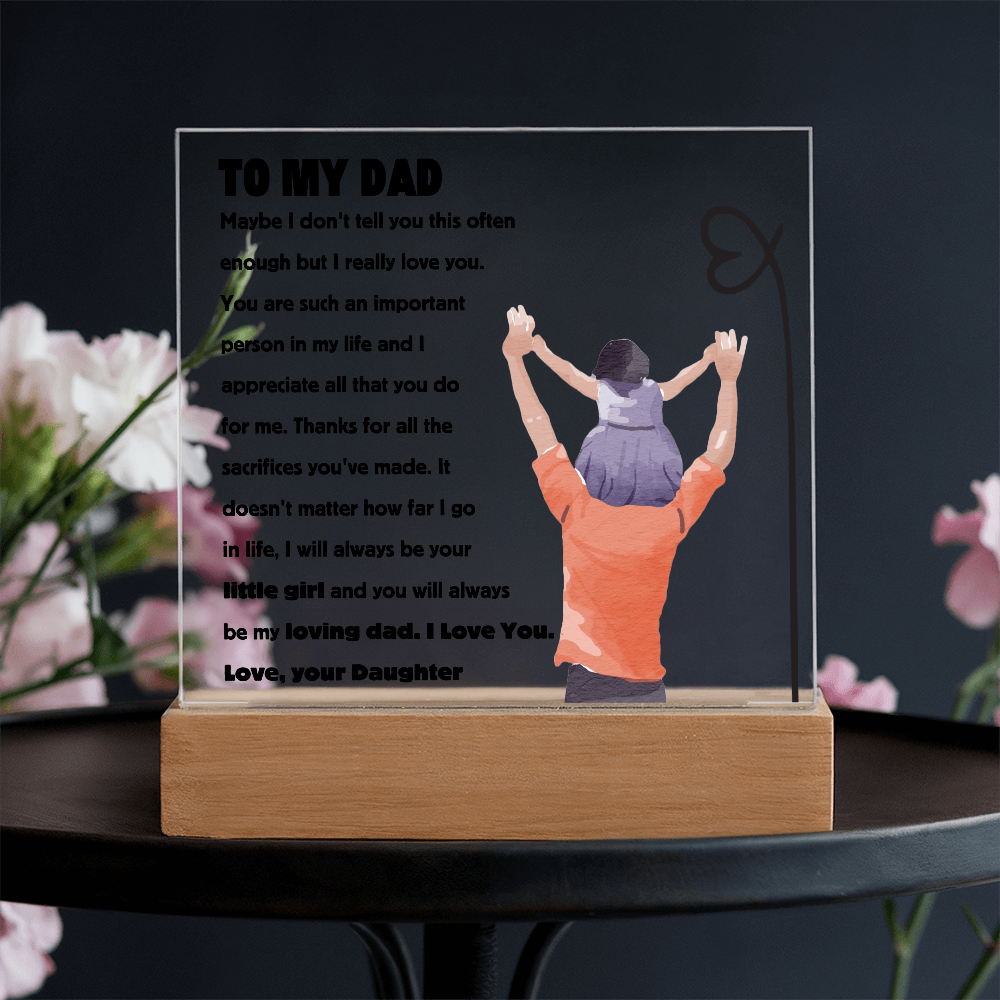 Square acrylic plaque with heartfelt message for dad, featuring illustration of child on father's shoulders, displayed on wooden stand.